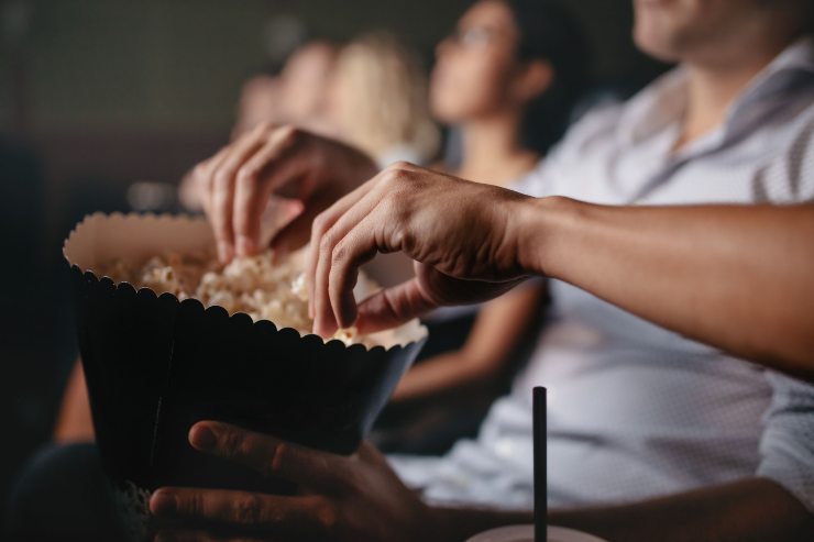 Persone che mangiano i popcorn al cinema