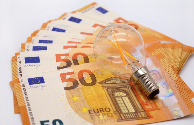 lampadina distesa sopra banconote da 50 euro