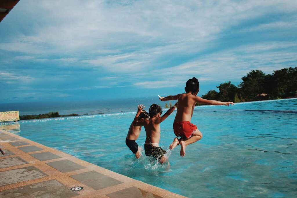Bambini che si tuffano in piscina